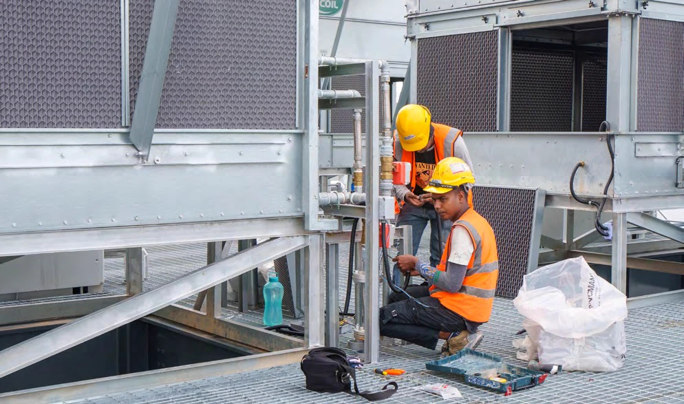 Technicians working on rooftop cooling towers